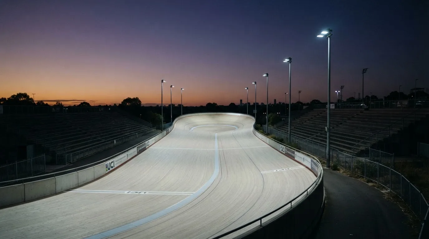 Een leeg voetbalstadion met lichtmasten bij schemering